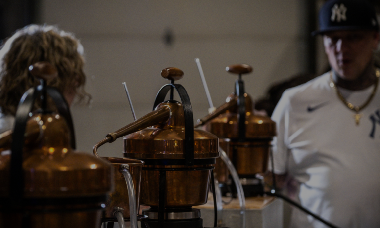 Gin still distilling custom gin blend while Master Distiller Kris looks on.